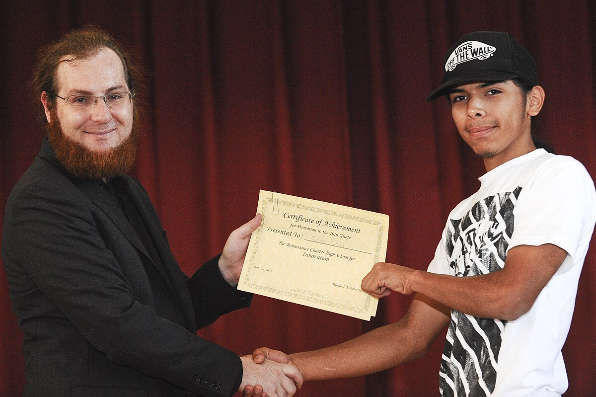 A person handing a diploma.