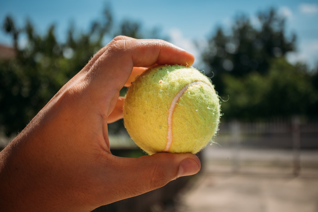A person holding a tennis ball.
