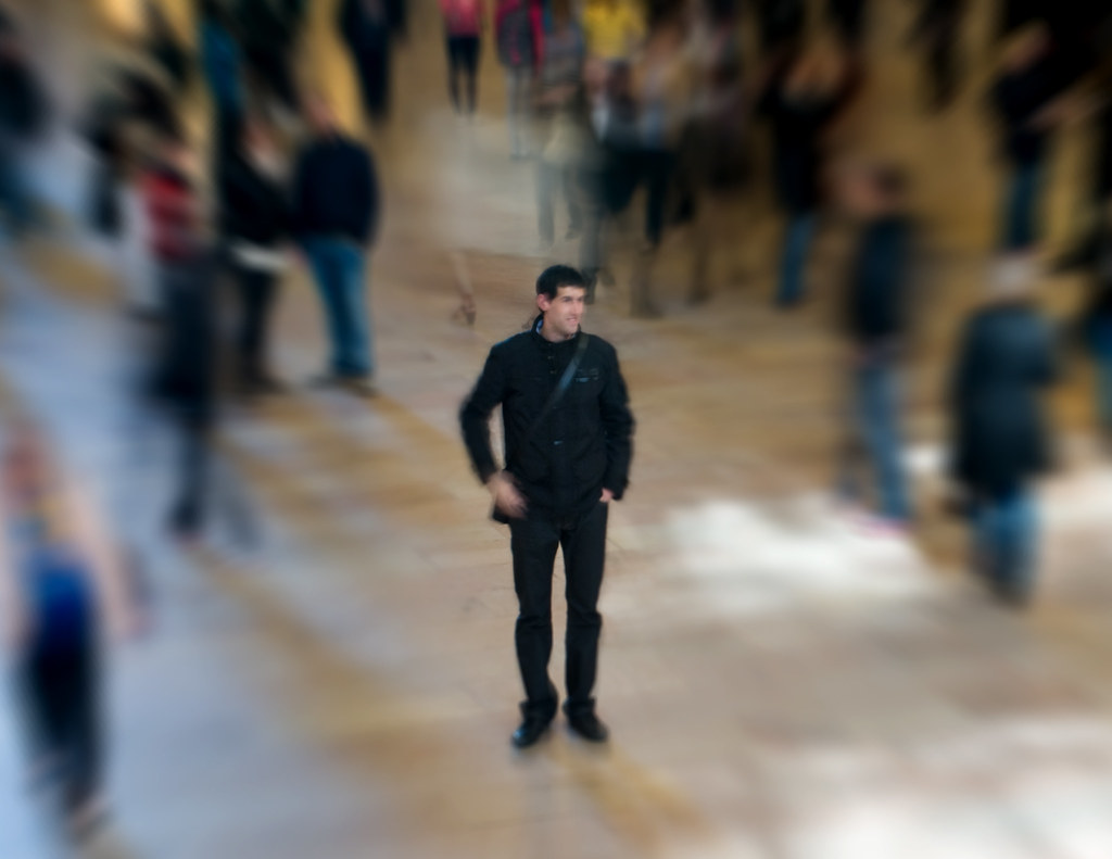A person standing confidently alone in a crowd.