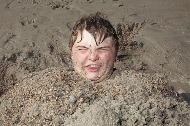 Man with head buried in sand