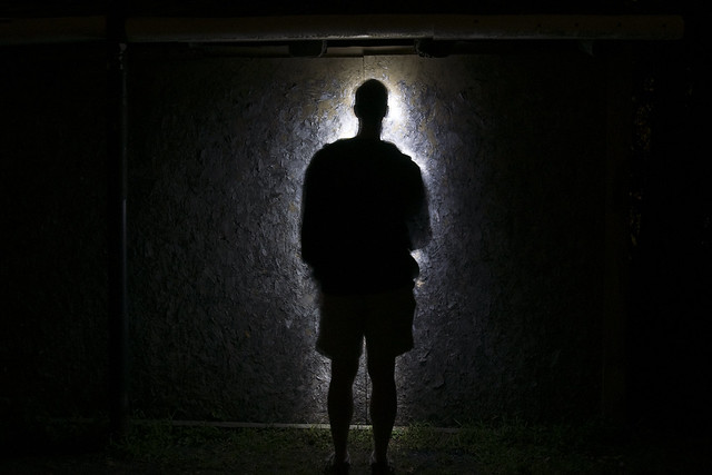 Person standing in front of a shadowy figure symbolizing fear