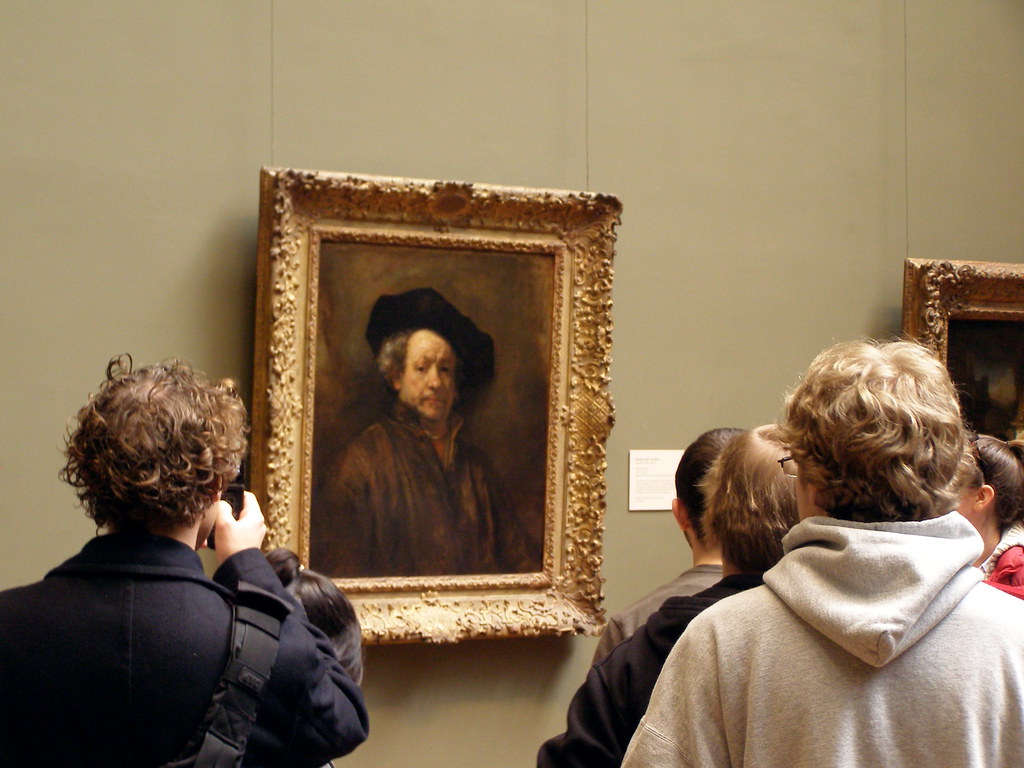 Two people looking at a painting from different angles